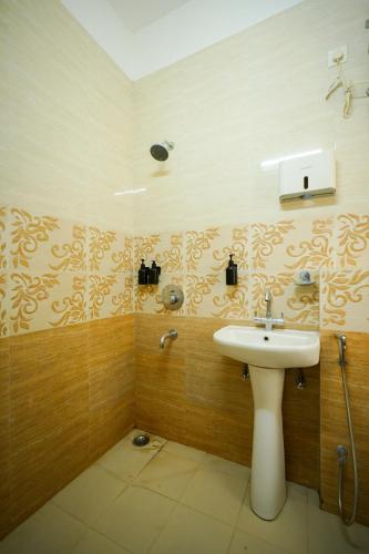 a bathroom with a sink and a shower at Hotel Banyan Courtyard Guwahati in Guwahati
