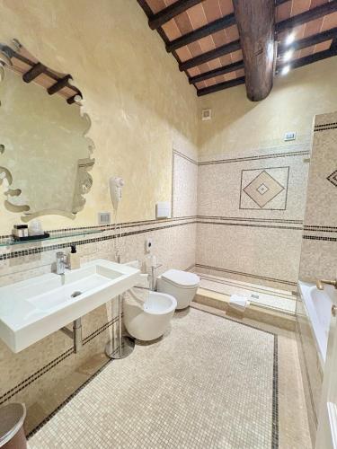 a bathroom with a sink and a toilet and a mirror at Antica Residenza Dell'Angelo in Lucca