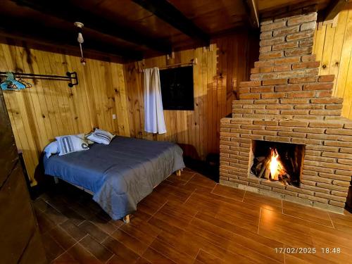 a bedroom with a bed and a brick fireplace at Cabaña Nido de Niebla en San José del Pacífico in San Jose del Pacifico