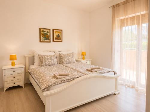 a white bedroom with a white bed and a window at Casa Sol Maris in Novigrad Istria