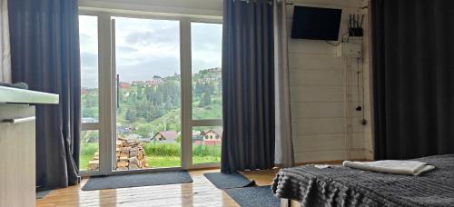 a bedroom with a large window with a view at Hotel Osher in Bukovel