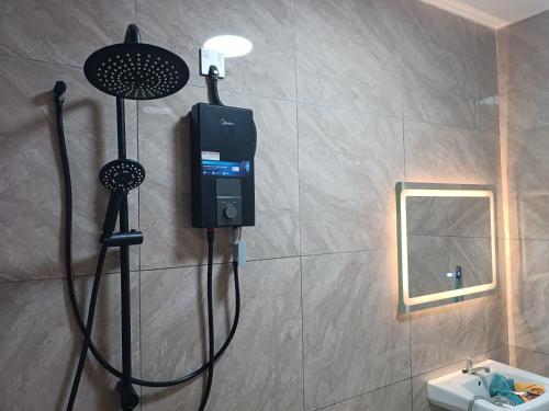 a bathroom with a soap dispenser on the wall at JayR Homestay Ambience Residence in Malacca