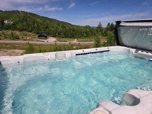a jacuzzi tub with a view of a mountain at Le Nordet - SPA & Play room in Saint Come