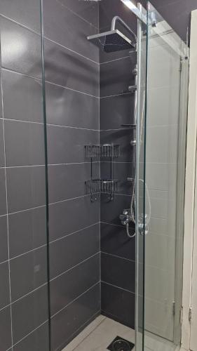 a bathroom with a shower with a glass door at White Bloom - Kfardebian 6836 in Kfardebian