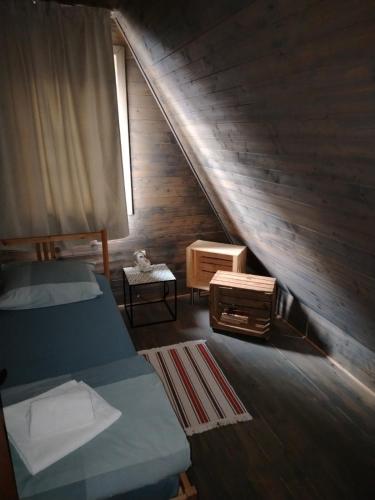 a attic room with two beds and a staircase at ZlatAir Eco Chalet in Nova Varoš