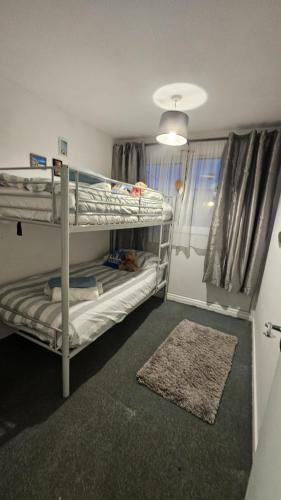 a small room with two bunk beds and a rug at Netty's Retreat in Hemsby