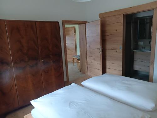 a bedroom with two beds and a wooden cabinet at Biohof Fötschl in Tamsweg