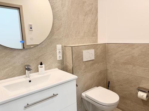 ein Badezimmer mit Waschbecken, Toilette und Spiegel in der Unterkunft Villa Cologne - Apartments & Monteursquartiere in Meckenheim bei Köln in Meckenheim