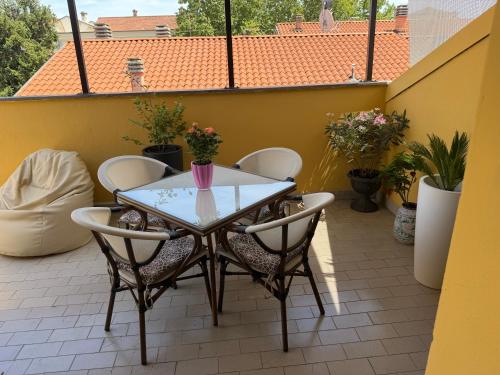 a table and chairs on a balcony with plants at La Coccola by Andrea in Castelfranco Emilia