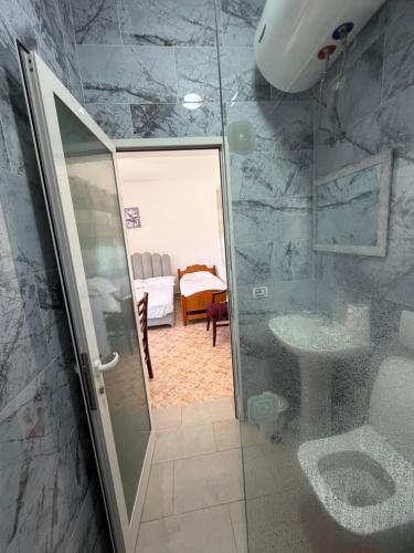 a bathroom with a shower and a toilet and a sink at Lalëz Villa Hoxha in Fushë-Draç