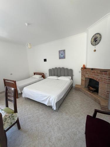two beds in a room with a fireplace at Lalëz Villa Hoxha in Fushë-Draç