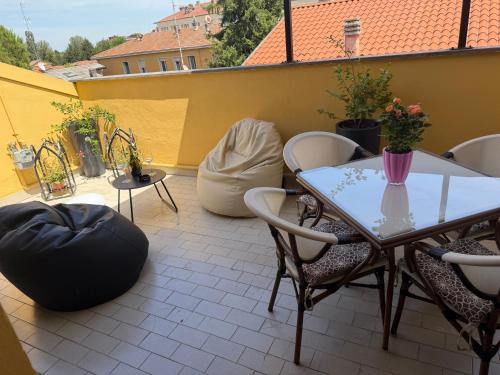 a patio with a table and chairs on a balcony at La Coccola by Andrea in Castelfranco Emilia