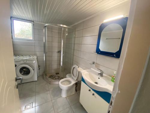 a bathroom with a sink toilet and a washing machine at Thassos Home in Skala Kallirachis