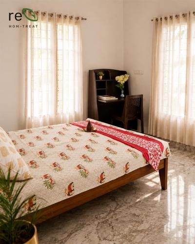 a bedroom with a bed and a desk in a room at Re-Leaf Hom-Treat Homestay in Wayanad