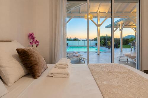 a bedroom with a bed and a view of a pool at Villa Noyanny Piscine Privée Calme in Le Moule