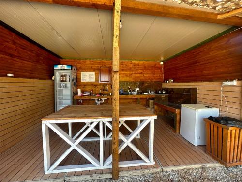 a kitchen with a large wooden table in a cabin at Bocana Camping Borsh in Borsh