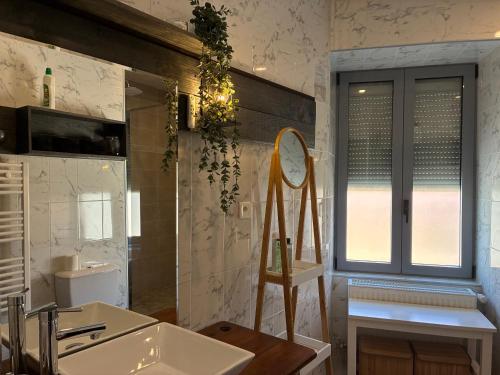 a bathroom with a sink and a mirror at Le 36 du prieuré in Arbois