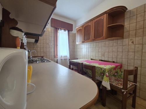 a kitchen with a counter and a table and chairs at Manuela in Bibione