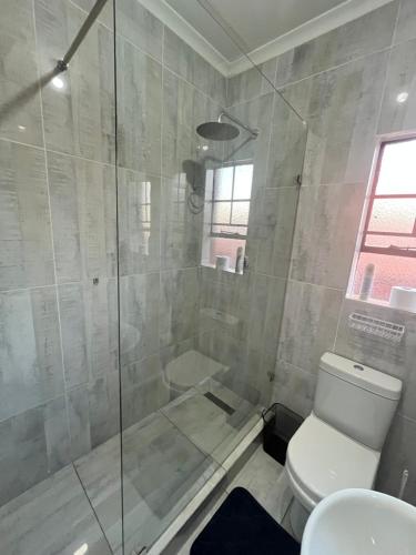 a bathroom with a glass shower with a toilet at Indumiso 80 in Newcastle