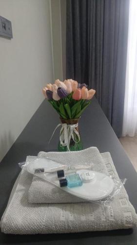 a table with a vase of flowers and a plate at Tabigat Hotel & Spa in Alga