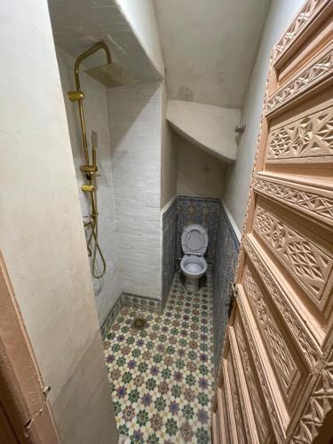 a small bathroom with a toilet and a door at Riad Marrakech Palacito in Marrakesh