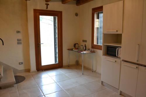 a kitchen with a refrigerator and a table and a door at Casale La Rocchetta in Lonigo