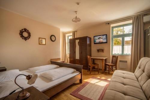 a bedroom with a bed and a couch and a table at Villa Parma in Maribor Self check - in in Maribor