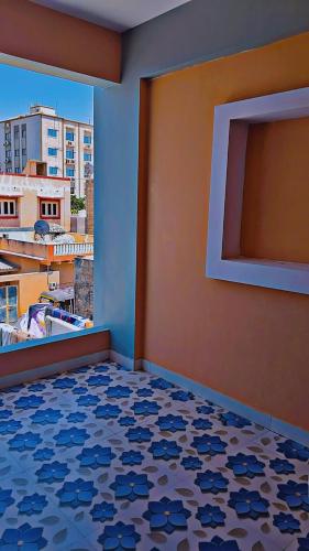 a room with a blue wall and a floor with a window at Radhe House in Dwarka