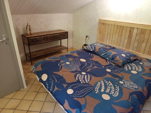 a bedroom with a bed with a colorful comforter at Gîte à la campagne in Laborel