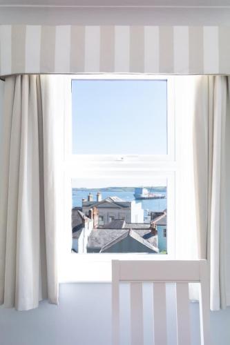 a window with a view of a city at Eagles Nest - By Rowes Retreats in Falmouth