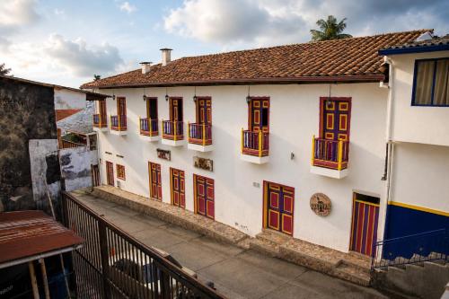 a white building with colorful windows and a balcony at Hotel Ciudad de Segorbe in Salento