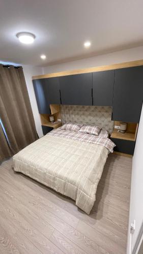 a bedroom with a bed with a large headboard at SunVillaTuzi in Tuzi