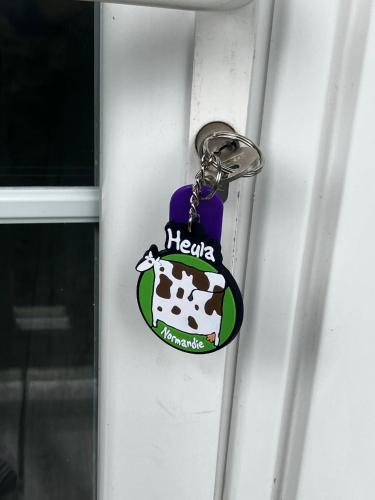 a key chain with a cow on it on a door at L'Ecrin Normand appartement avec jardin comportant 2 lits 2 places et 1 lit 1 place in Cambremer
