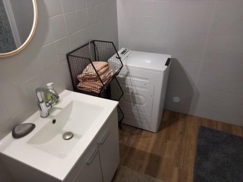 a bathroom with a sink and a washing machine at Gîte à la campagne in Laborel