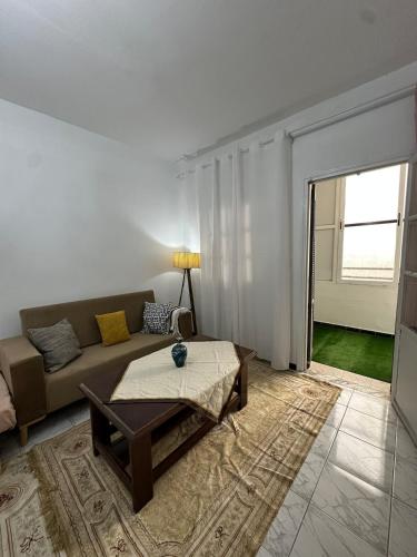 a living room with a couch and a table at appartement cozy in Kolea