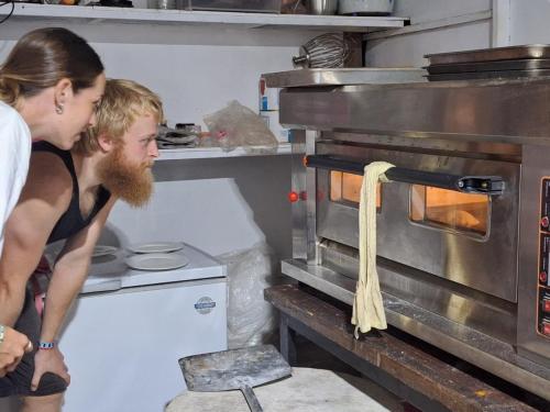 a man and a woman in a kitchen with an oven at Fat Monkey in Koh Rong Island