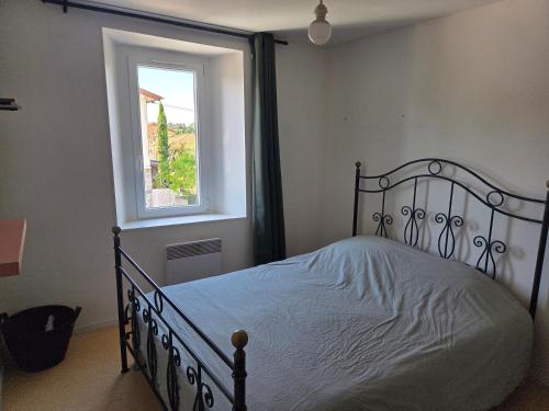 a bedroom with a bed and a window at comfortable village house in Le Fossat