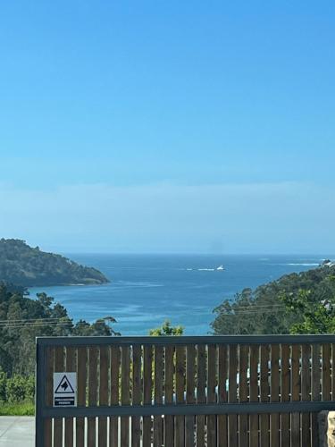 a bench with a view of the ocean at A Casa da Moucha in Muxia