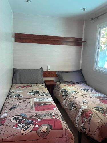 a bedroom with two beds and a window at Mobil home devant un grenadier in Gémenos
