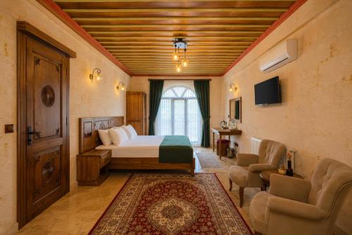 a bedroom with a bed and a couch and a window at Mai Cappadocia in Göreme