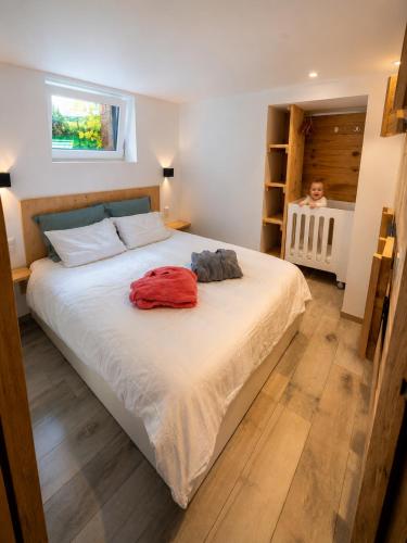 a bedroom with a large bed and a child in a crib at Ô17 Séjour wellness avec bain nordique à 5 min de Namur in Namur