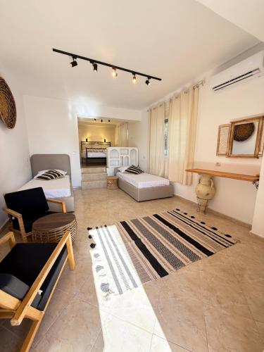 a living room with a couch and a bed and a rug at Casa Boha Garden in Dhërmi
