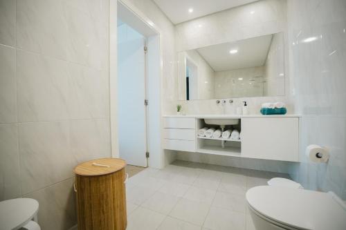a bathroom with a toilet and a sink and a mirror at Casa do Horizonte in Ribeira Grande