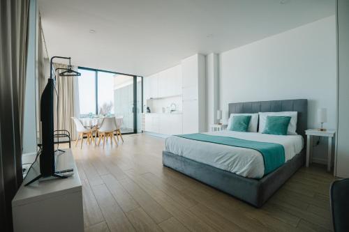 a bedroom with a large bed and a dining room at Casa do Horizonte in Ribeira Grande
