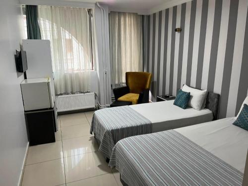 a hotel room with two beds and a chair at LOTUS OTEL in Konya