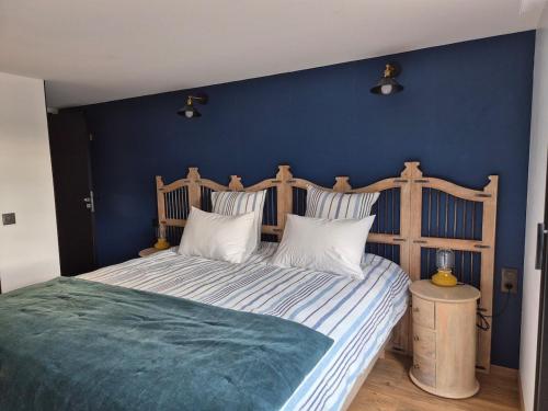 a bedroom with a large bed with a blue wall at Le logis de la mésanges Bleue in Gignac