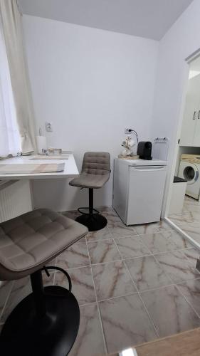 Eine Küche mit zwei Stühlen, einem Tisch und einer Theke in der Unterkunft VivaVero in Baia Mare