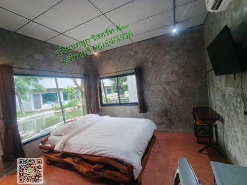 a large bed in a room with a window at บ้านนกฮูกรีสอร์ท in Ban Chamun (2)