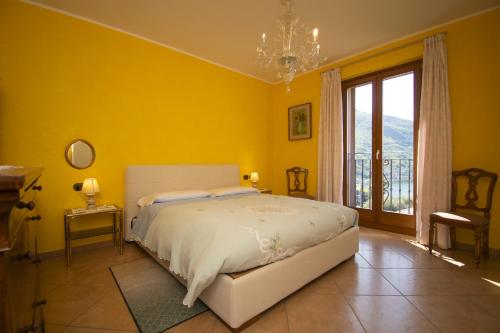 a bedroom with a bed and a yellow wall at Albergo Ristorante Conca Azzurra in Colico