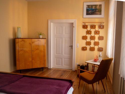 a bedroom with a bed and a table and a door at Das Wilde 70er in Dobritz